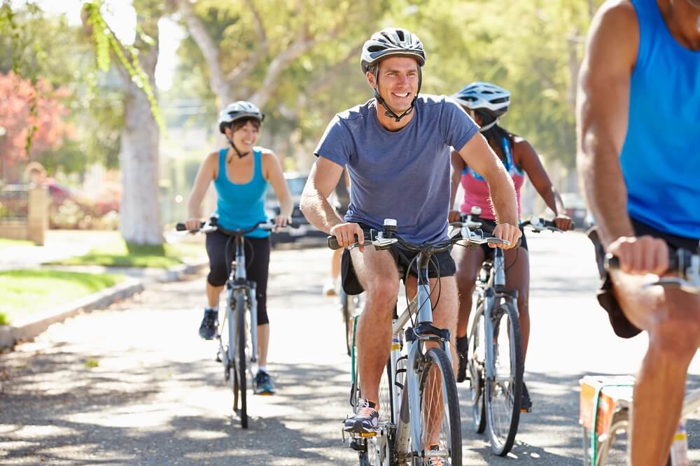 Group of cyclists in the park wearing helmets.