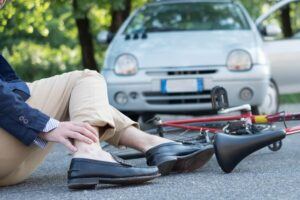 Injured cyclist on the asphalt after bicycle accident.