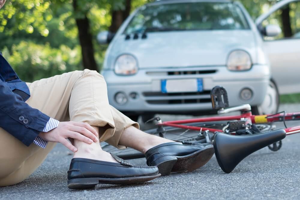 Injured cyclist on the asphalt after bicycle accident.