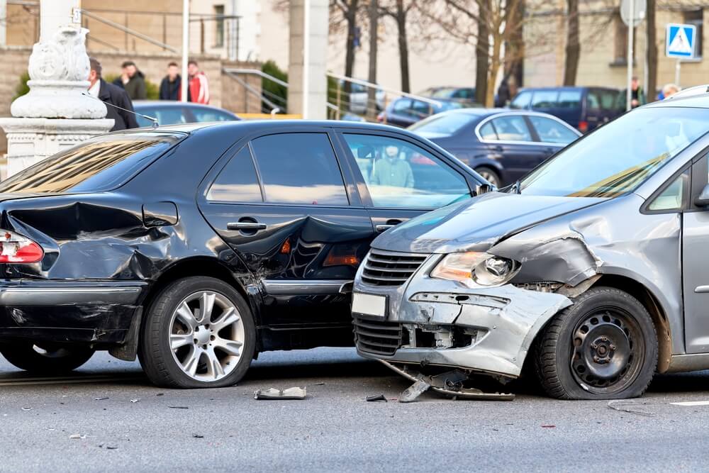 Two cars slide past each other in a collision at the highway.